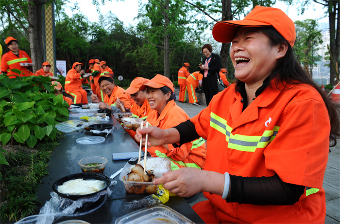 环卫工人开心地吃着涪陵区餐饮行业协会志愿者送来的豆花饭.jpg