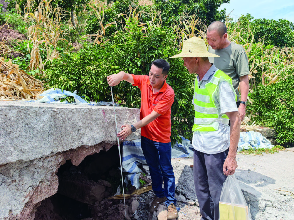 蒋毅(左)在测量公路沉降数据.png ""
